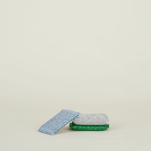 The Lurex Sponge Set (Set of 3) in blue, green, and silver by Hawkins New York adds charm to your cleaning routine while making chores easier against a simple light background.