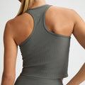 Seen from the back, someone wears the Ribbed R Tank in olive green by Rohnisch, made from recycled polyester.