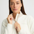 A person wearing a Rohnisch Thermal Half Zip Fleece, made from recycled polyester, holds the zipper against a plain, light-colored background.