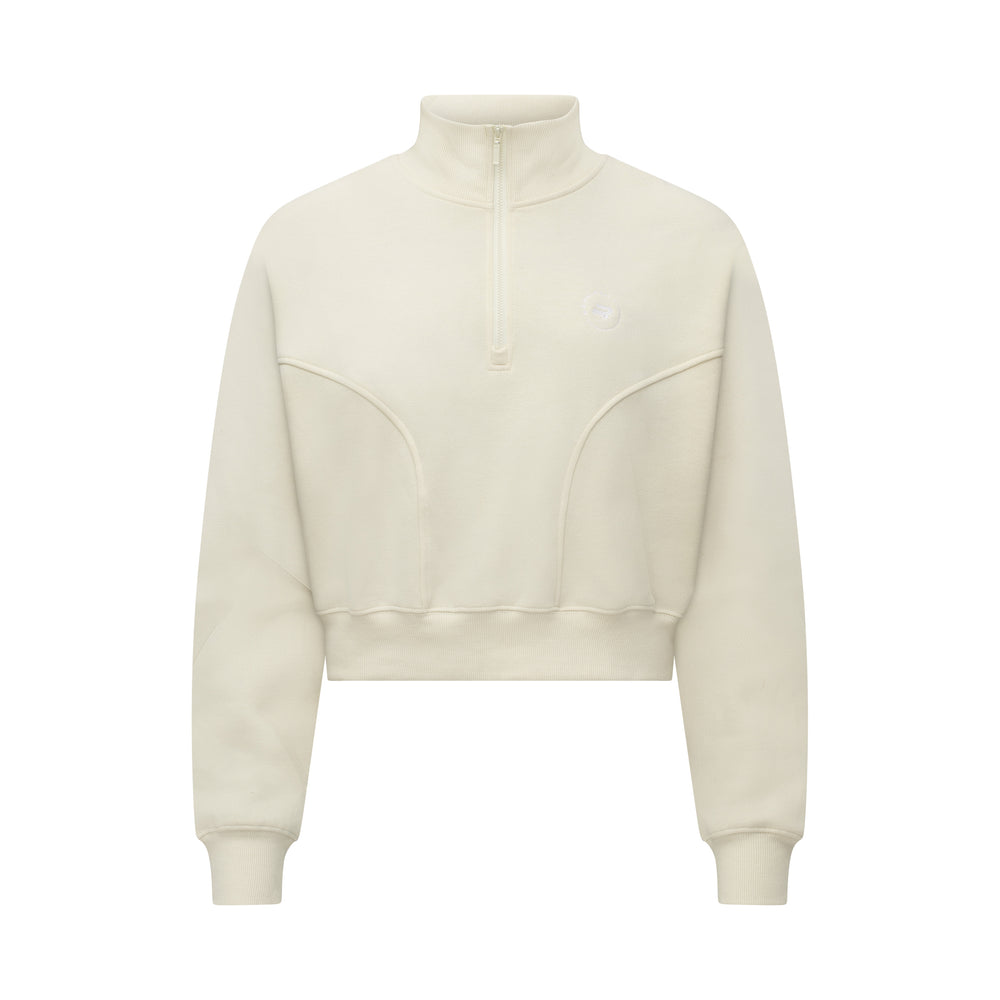 The Rohnisch Soft Sweat Half Zip, a cream-colored cropped sweatshirt, features a minimalist design with a high collar. Crafted from premium terry quality fabric, it offers a snug fit that effortlessly blends style and comfort.