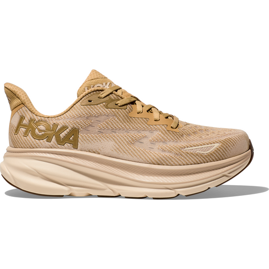 A tan Hoka M Clifton 9, Wheat/Shifting Sand athletic shoe with a thick, protective cushioned sole and lace-up design, featuring the brand's logo prominently on the side and offering a responsive toe-off for enhanced performance.