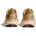 A pair of Hoka M Clifton 9 running shoes in Wheat/Shifting Sand, viewed from the back, showcasing the brand name and the wavy tread pattern on the rubber soles. The design highlights a responsive toe-off and a protective cushion for superior comfort.