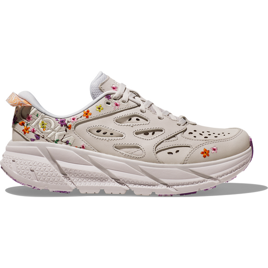Side view of a beige sneaker with floral embroidery, featuring a thick white sole and perforated designs on the upper, delivering a lightweight ride similar to the comfort found in Hoka W Clifton L BP, Nimbus Cloud/Nimbus Cloud.