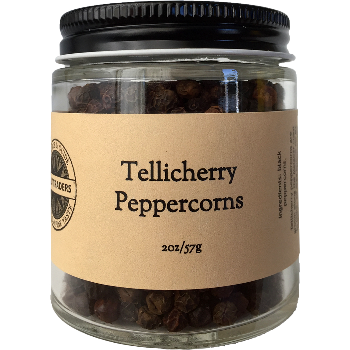 A glass jar with a black lid contains Tellicherry Black Pepper from Salt Traders, labeled 2oz/57g. These peppercorns hail from the Malabar Coast in Kerala.