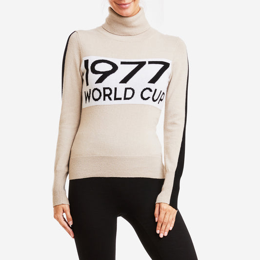 Someone wearing the We Norwegians W World Cup Sweater, a beige Merino wool turtleneck with "1977 World Cup" text on the front.