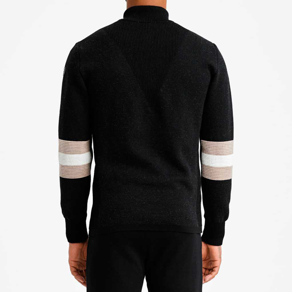 Viewed from the back against a light gray background, a person wears the We Norwegians M Hafjell Zip Up, featuring black merino wool with tan and white striped sleeves.