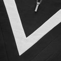 Close-up of We Norwegians W Voss Chevron Zip-Up, featuring black Merino wool with a white chevron stripe and a metal zipper pull, tailored to women's sizing.