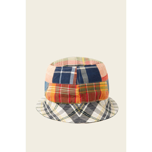 A vibrant and stylish reversible bucket hat by Original Madras Trading Co., showcasing a patchwork design with various plaid and checkered sections on a beige background, known as the Blue Multi.