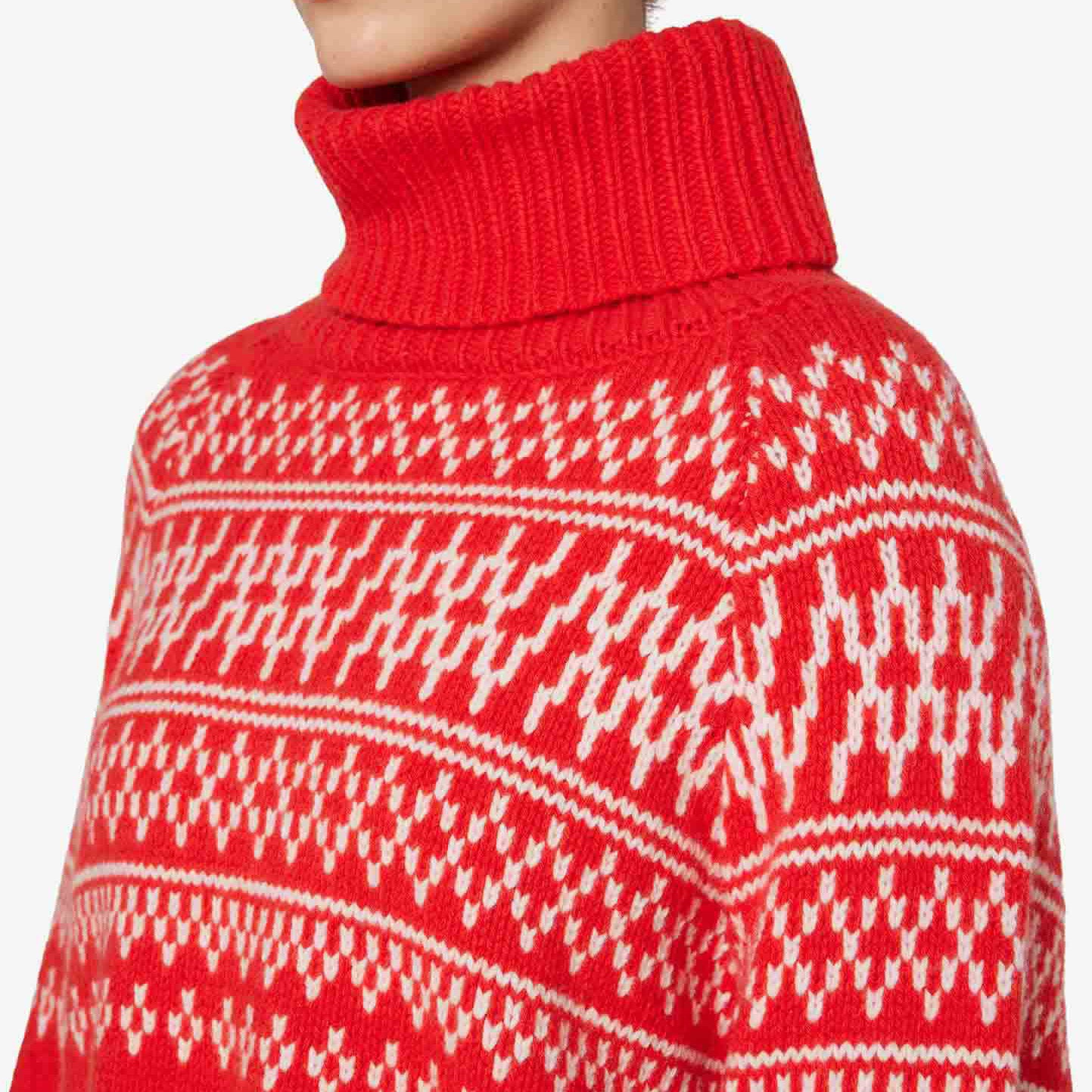 A person is seen from the shoulders up wearing the We Norwegians W Setesdal Sweater, a red and white patterned turtleneck made of luxurious Merino wool.