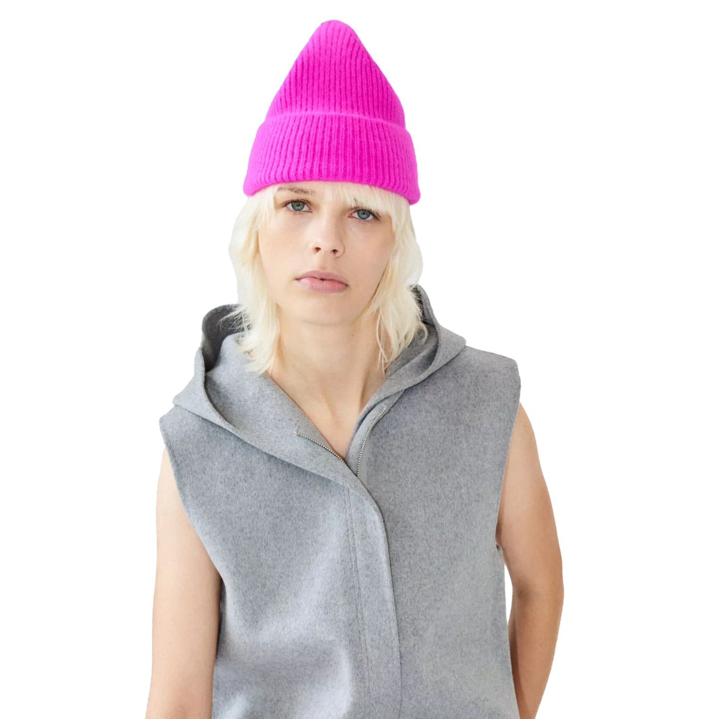 A person wearing a bright pink Le Bonnet lambswool beanie and a sleeveless gray hoodie, with a neutral expression.