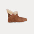 The Emmy Slipper by Shepherd of Sweden in Moro/Chestnut features a brown suede exterior with a fluffy cream inner lining and a red fabric strip at the back, showcased on a light background.