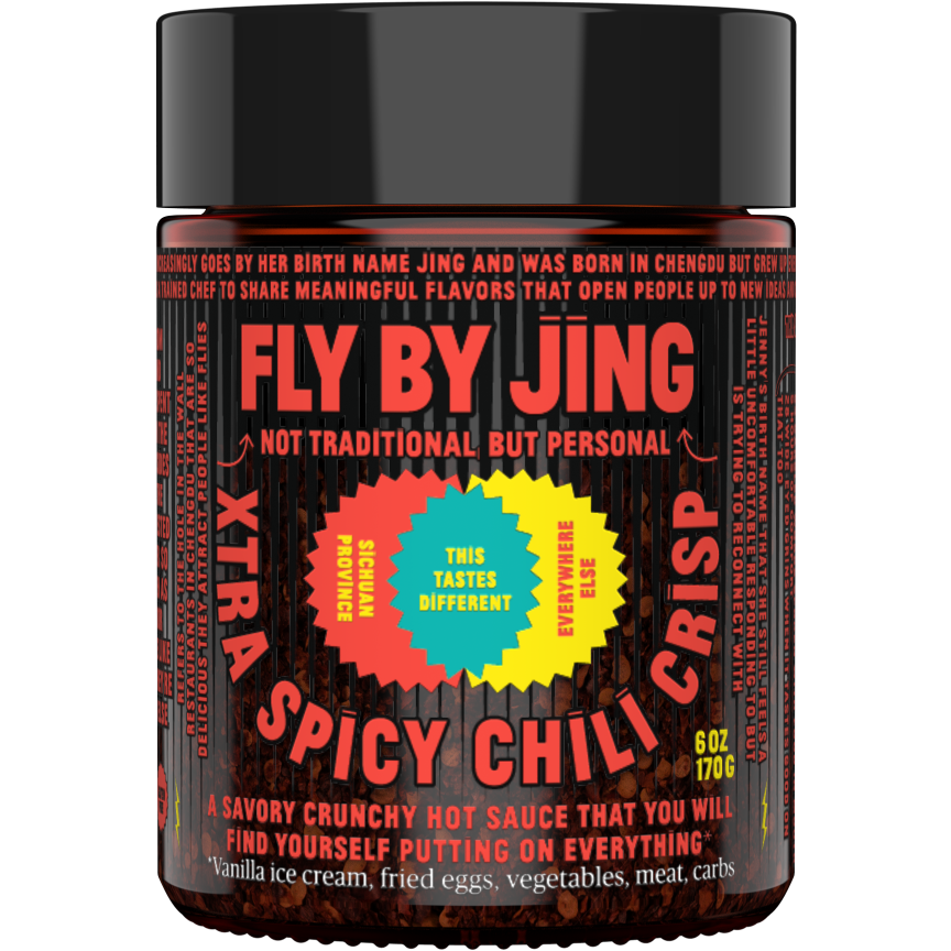 A jar of Fly By Jing Xtra Spicy Chili Crisp. The label highlights its unique flavor and versatile use on dishes like ice cream, eggs, and vegetables. Made with the hottest Chinese chilis, this 6 oz (170g) jar delivers an intense heat that's perfect for any spicy food lover.