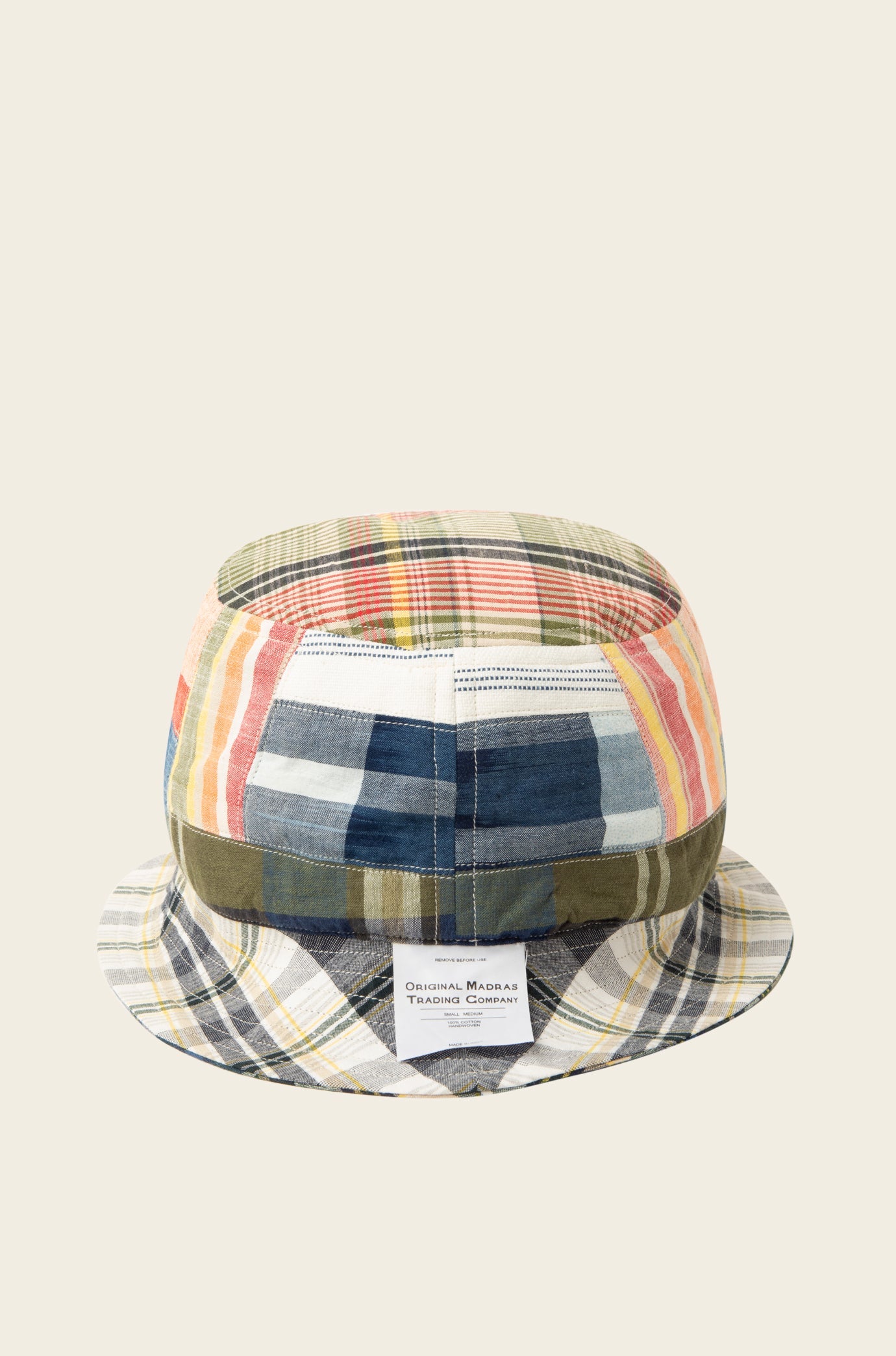 The Reversible Bucket Hat, Blue Multi from Original Madras Trading Co. showcases a vibrant, multi-patterned plaid design in an array of green, yellow, red, and blue shades and includes a small white tag on the front.