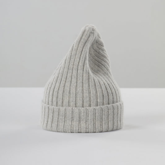 The Le Bonnet Large Beanie in Silver, made in Scotland, is a chunky ribbed knit with a pointed top, displayed upright against a light surface and plain background.