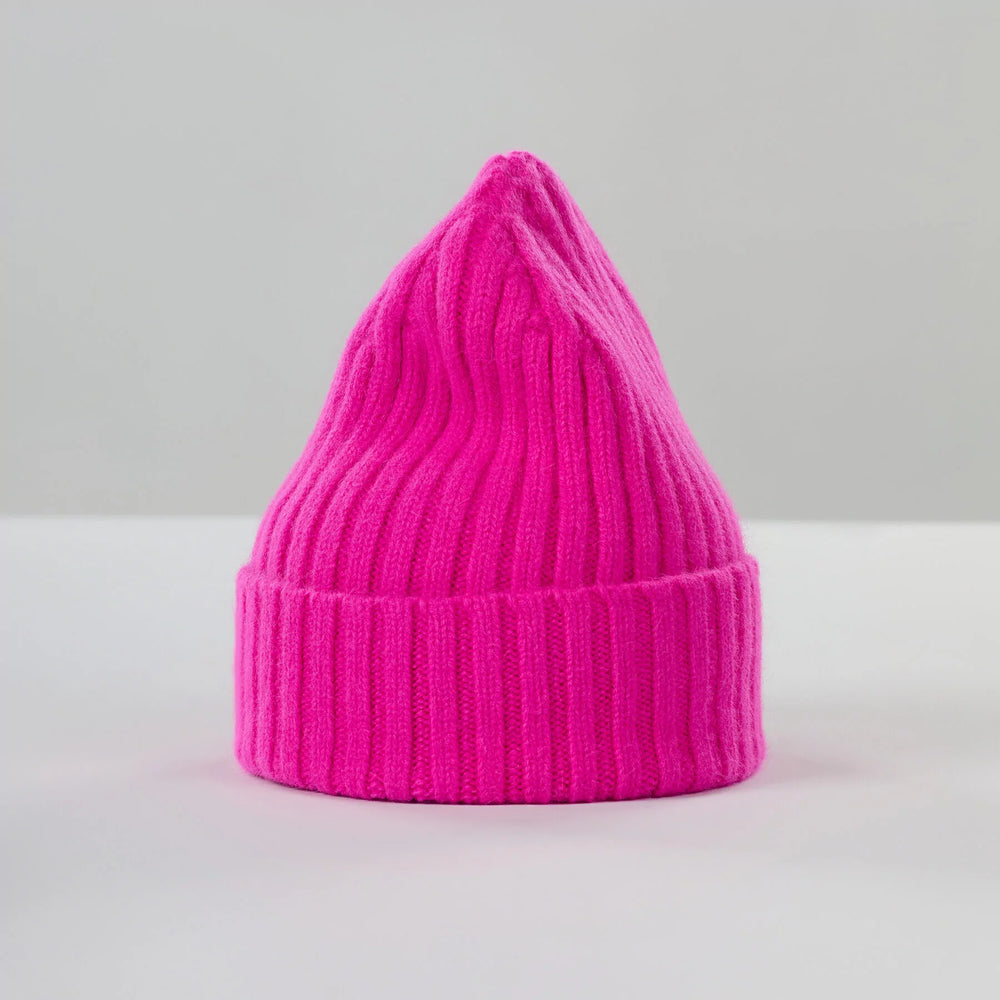 The Poppy Pink Large Beanie by Le Bonnet is crafted from soft, biodegradable lambswool and features a pointed top. It's displayed upright against a light gray background.