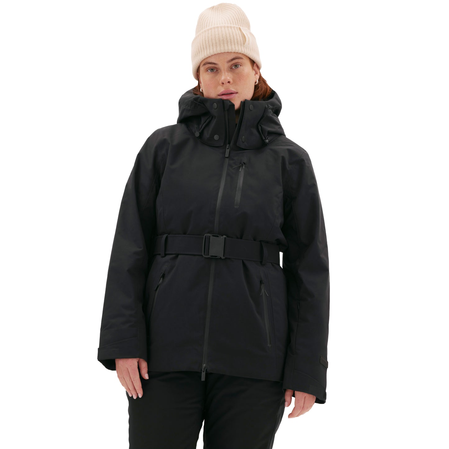 A person wearing a black Aston Jacket by Halfdays and a beige beanie stands against a white background, embodying a performance-driven style perfect for the mountains.