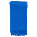 The Classic Throw by Alashan, a bright blue fringed blanket made from luxurious Australian merino wool, is folded neatly.