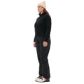 Dressed in Halfdays' Bonnie Fleece Top paired with black pants and a beige beanie, a person in ski boots stands against a white background, epitomizing high-alpine classic style.