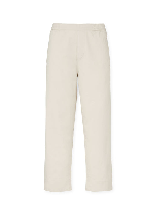 The Coco Pant Twill by Aiayu are beige straight-leg pants crafted from organic cotton twill, featuring an elastic waistband, front seam detailing, and a relaxed fit.