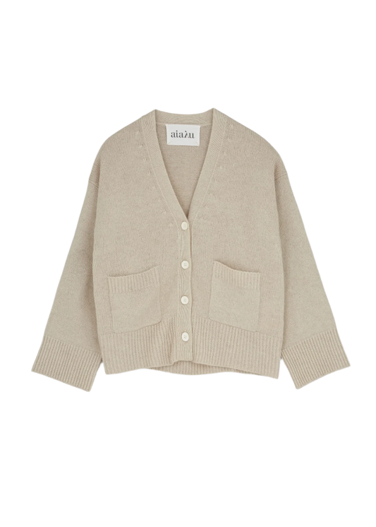 The Cora Cardigan by Aiayu is a beige, V-neck, button-up sweater featuring long sleeves, two front pockets, and ribbed cuffs.