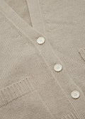 Close-up of the Cora Cardigan by Aiayu, a beige knitted design with white buttons, featuring a V-neck and front pockets.