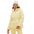 A person wearing the Halfdays Hedy Puffer Jacket in light yellow, featuring mountain performance attributes, along with matching pants and a cream beanie, stands against a white background.