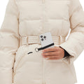 A person in the Hedy Puffer Jacket by Halfdays, celebrated for its mountain performance features, holds a smartphone attached to a strap.