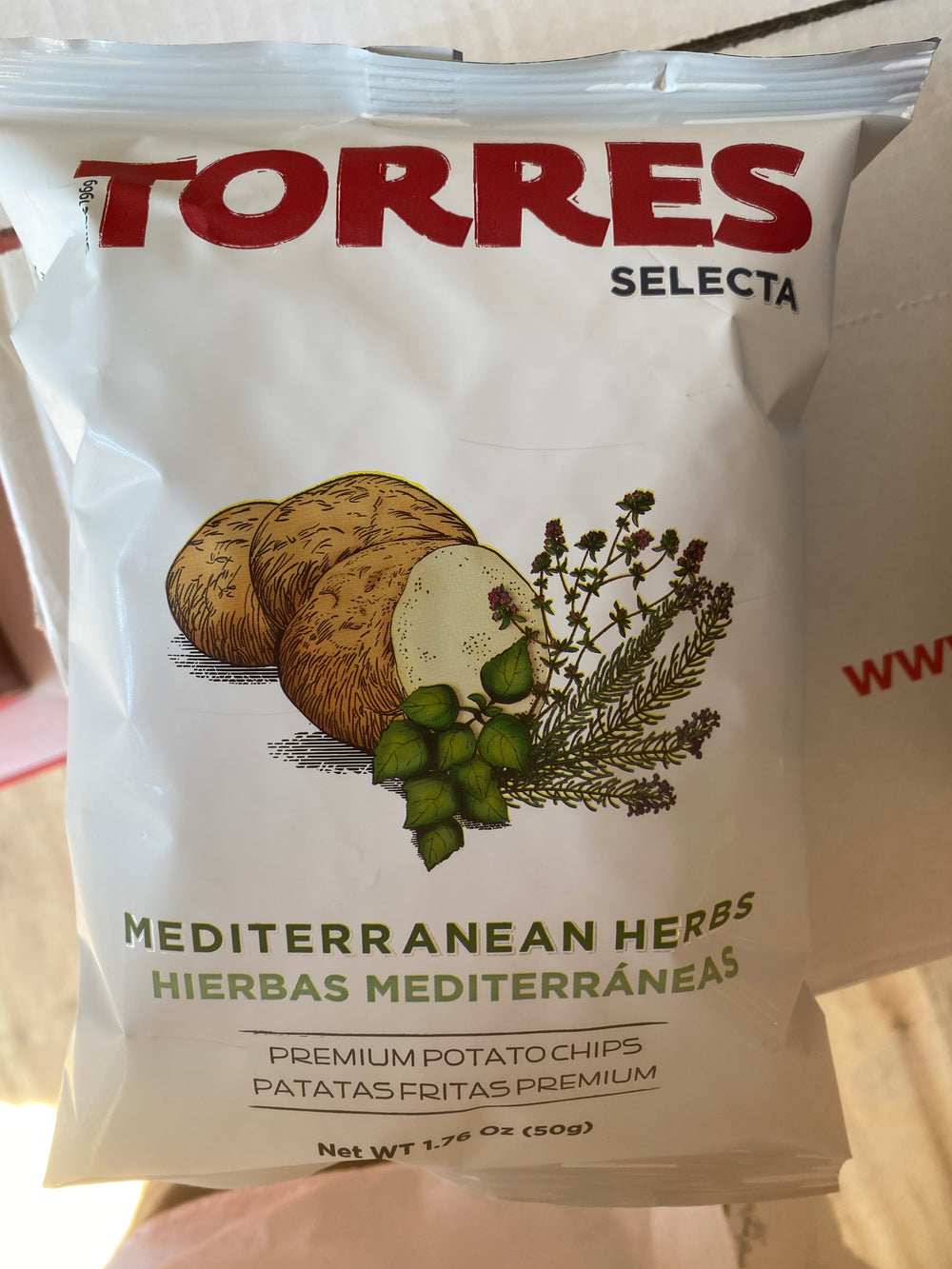 A bag of Westerlind's Mediterranean Herbs Chips small - Torres, featuring a white packaging adorned with an illustration of potatoes and herb sprigs. The net weight is 1.76 oz (50g).