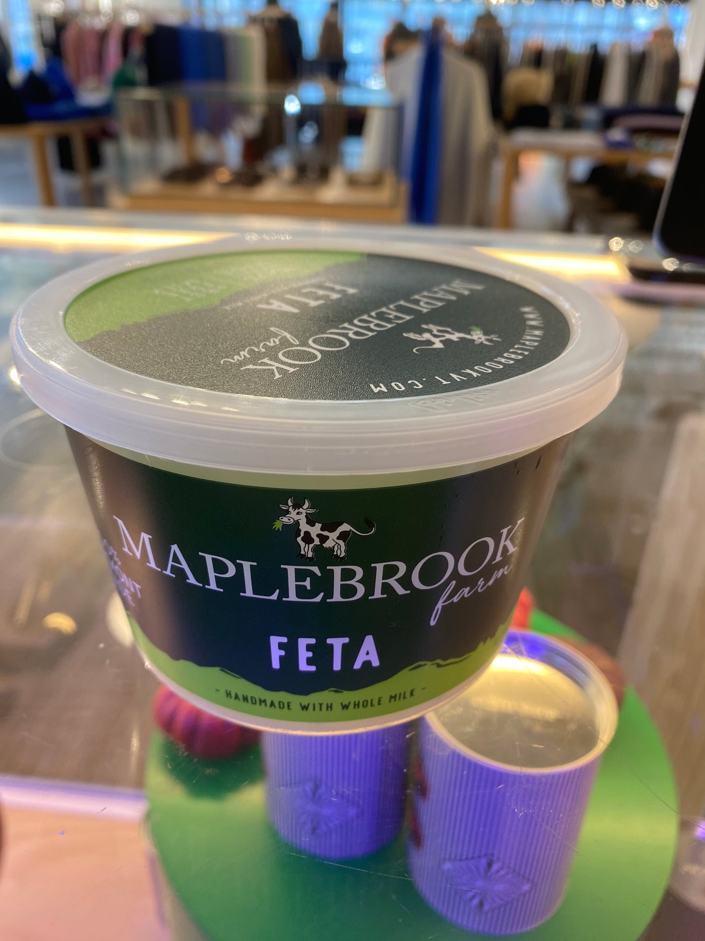 A container of Maplebrook Feta by Westerlind, featuring a green and black label, is on display in a store.