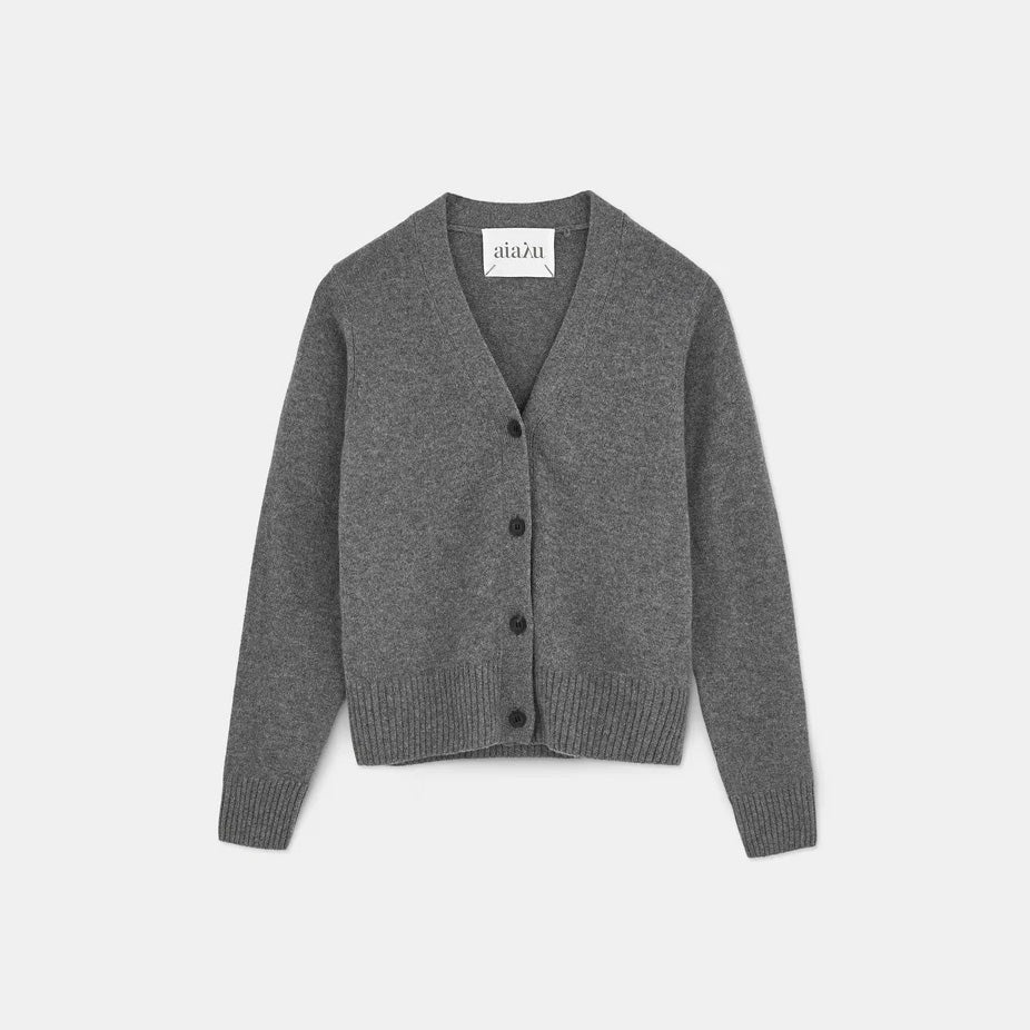 The Ingrid Cashmere Cardigan by Aiayu is a gray V-neck with a feminine fit, detailed with horn buttons and ribbed cuffs, laid flat on a white background.