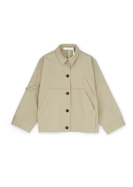 The Jules Jacket by Aiayu is a beige, long-sleeve piece crafted from weather-resistant Ventile fabric. It features a front button closure, collar, and two large front pockets. Enjoy its oversize fit for added comfort and style.