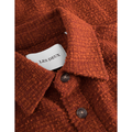 Close-up of a rust-colored "Kevin Boucle Shirt, Court Orange" with a visible label reading "Les Deux" inside the collar, and two brown buttons.