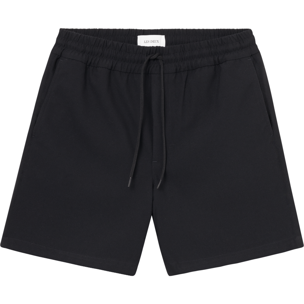 A pair of Patrick Twill Shorts, Dark Navy by Les Deux with a stretchy drawstring waist, side pockets, and a long-lasting twill weave is displayed against a white background.