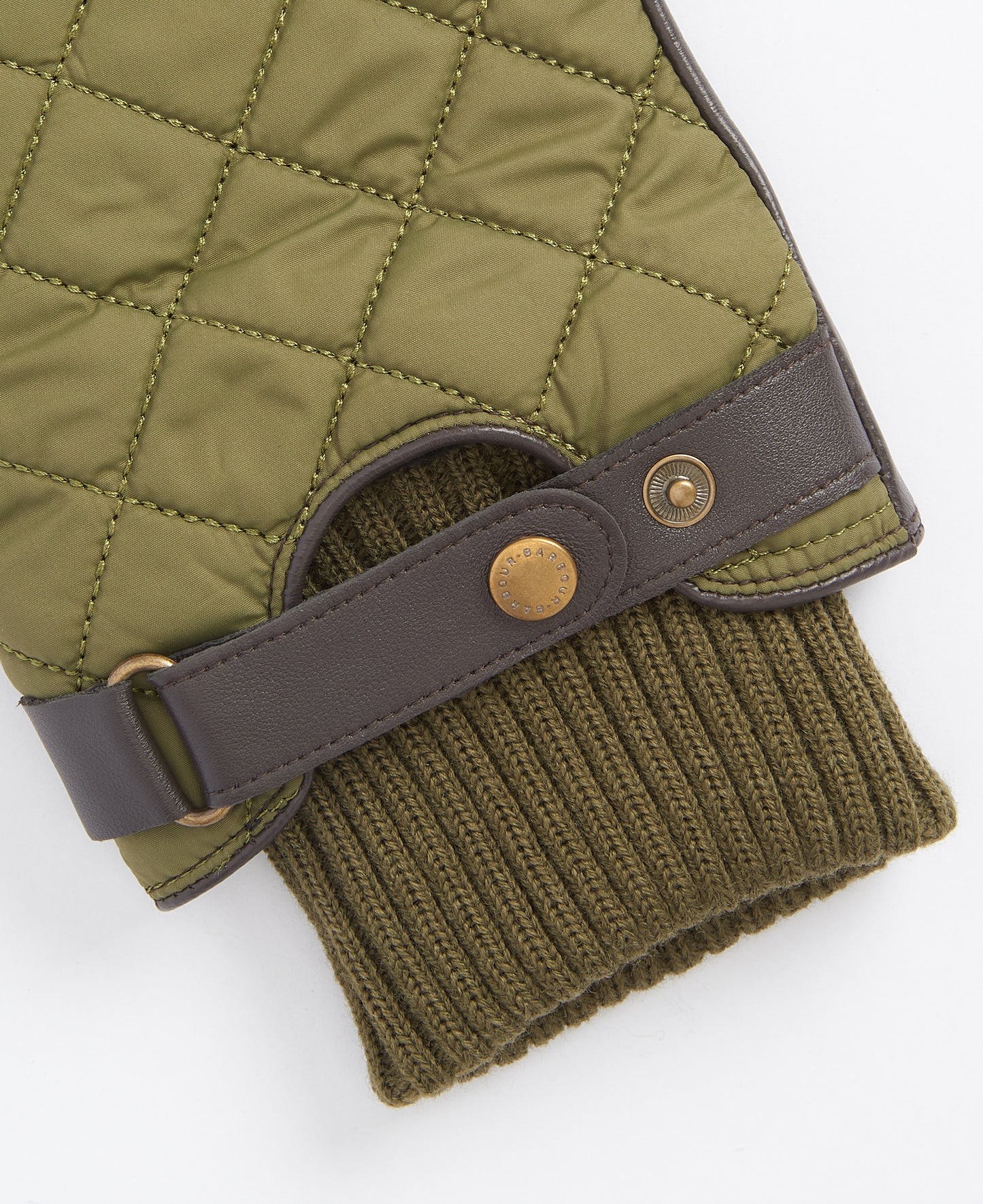 Close-up of a Barbour Singsby Glove, showcasing its quilted green design with brown leather strap detailing and button fastener, complemented by a ribbed knit cuff.