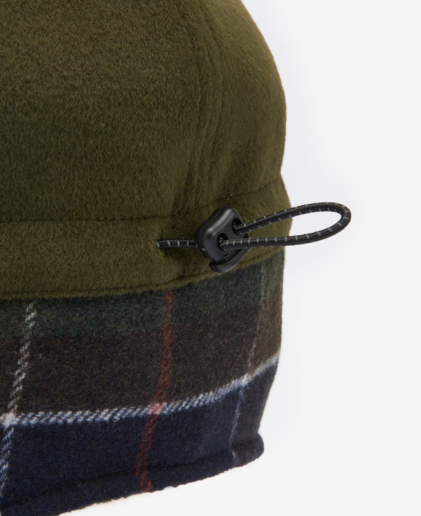 A close-up of the Barbour Lewis Trapper Hat, showcasing its green and plaid fabric with a drawstring and plastic toggle on the side.