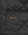 Close-up of a Quilted Zip-In Liner made from diamond quilted nylon, featuring a visible pocket with "Barbour" embroidered in brown thread above it.