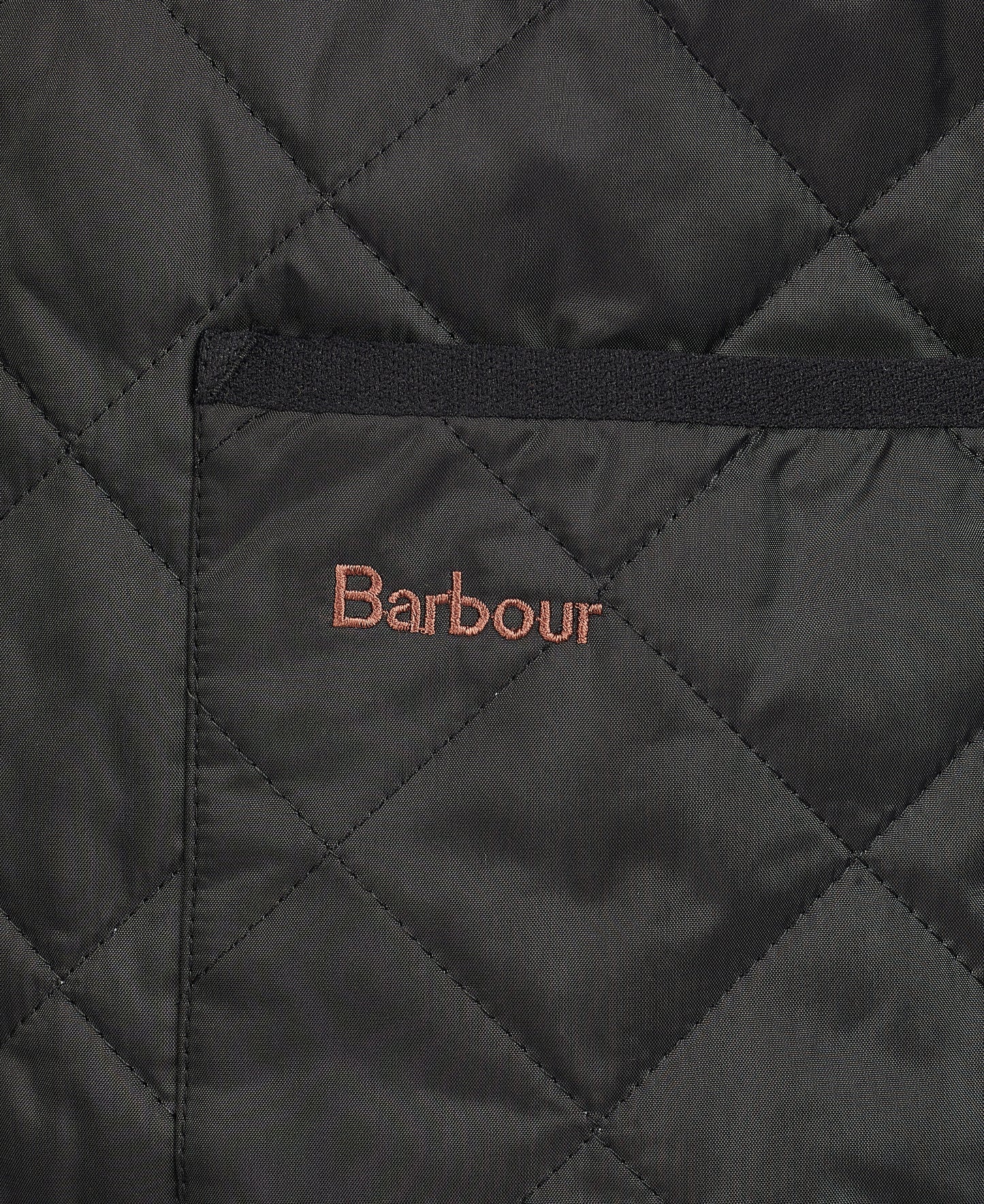 Close-up of a Quilted Zip-In Liner made from diamond quilted nylon, featuring a visible pocket with "Barbour" embroidered in brown thread above it.