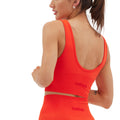 A person in a Halfdays Marie longline seamless top and shorts, displaying the engineered compression design, is facing partly away.