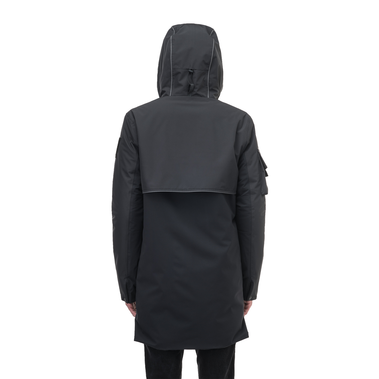 A person wearing the Nobis Alta Men's Performance Shell Jacket, a long, dark hooded raincoat with seam-sealed construction, faces away from the camera.