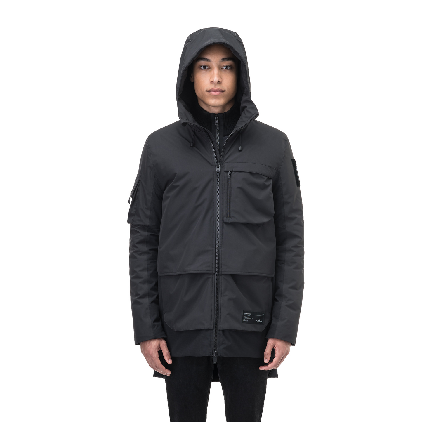 A person wearing the Nobis Alta Men's Performance Shell Jacket, a black hooded jacket with a durable water-repellent finish and multiple pockets, stands against a white background.