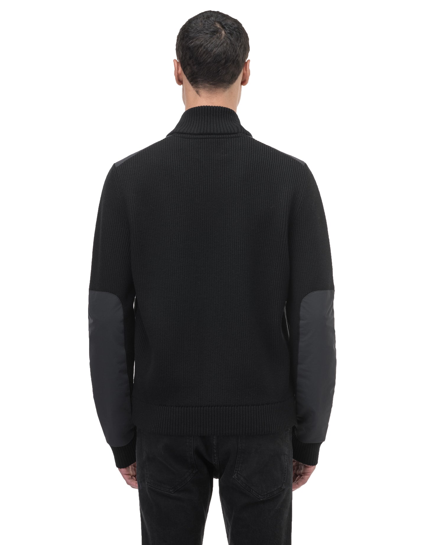 A person is wearing the Ero Men's Tailored Hybrid Sweater by Nobis, featuring quilted elbow patches, with their back facing the camera.