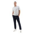 A person stands with hands in pockets, wearing a light gray T-shirt, Herno M Laminar Nylon Pants in Navy with an adjustable drawstring, and white sneakers, against a plain white background.