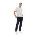 A man stands with hands in his pockets, wearing a white t-shirt, Herno M Laminar Nylon Pants, Navy with an adjustable drawstring, and white sneakers against a plain white background.