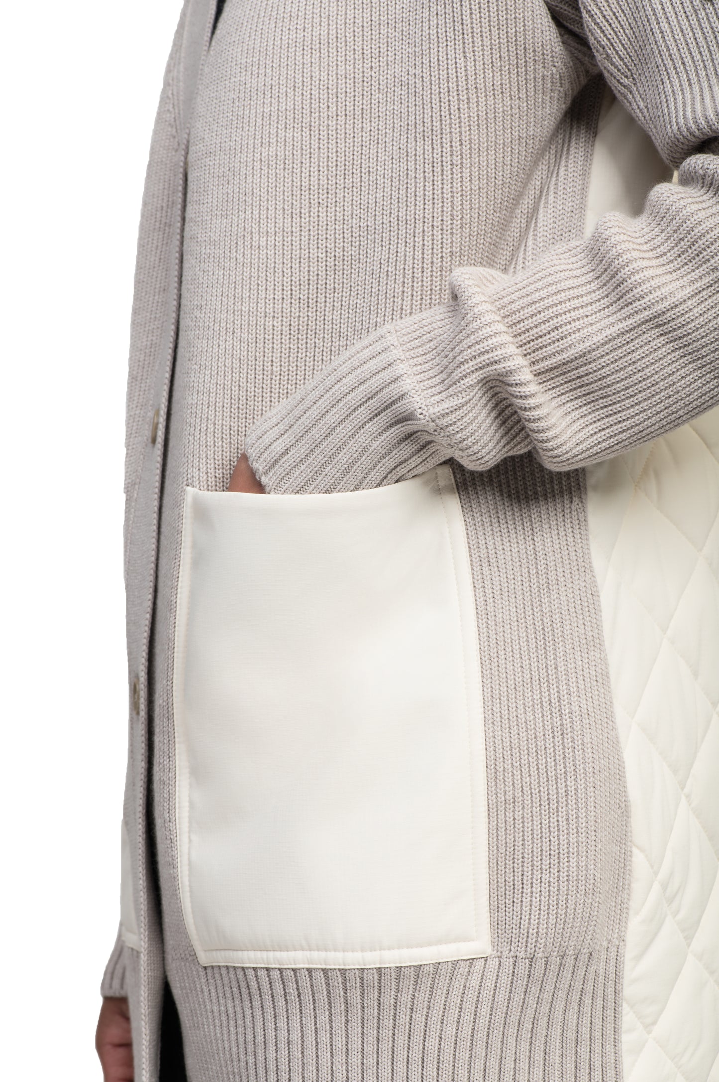 Close-up of a person wearing the Riga Tailored Button Front Cardigan by Nobis, designed in light gray and made from 100% virgin extra fine merino wool, showcasing a large white pocket and quilted detail on the side.