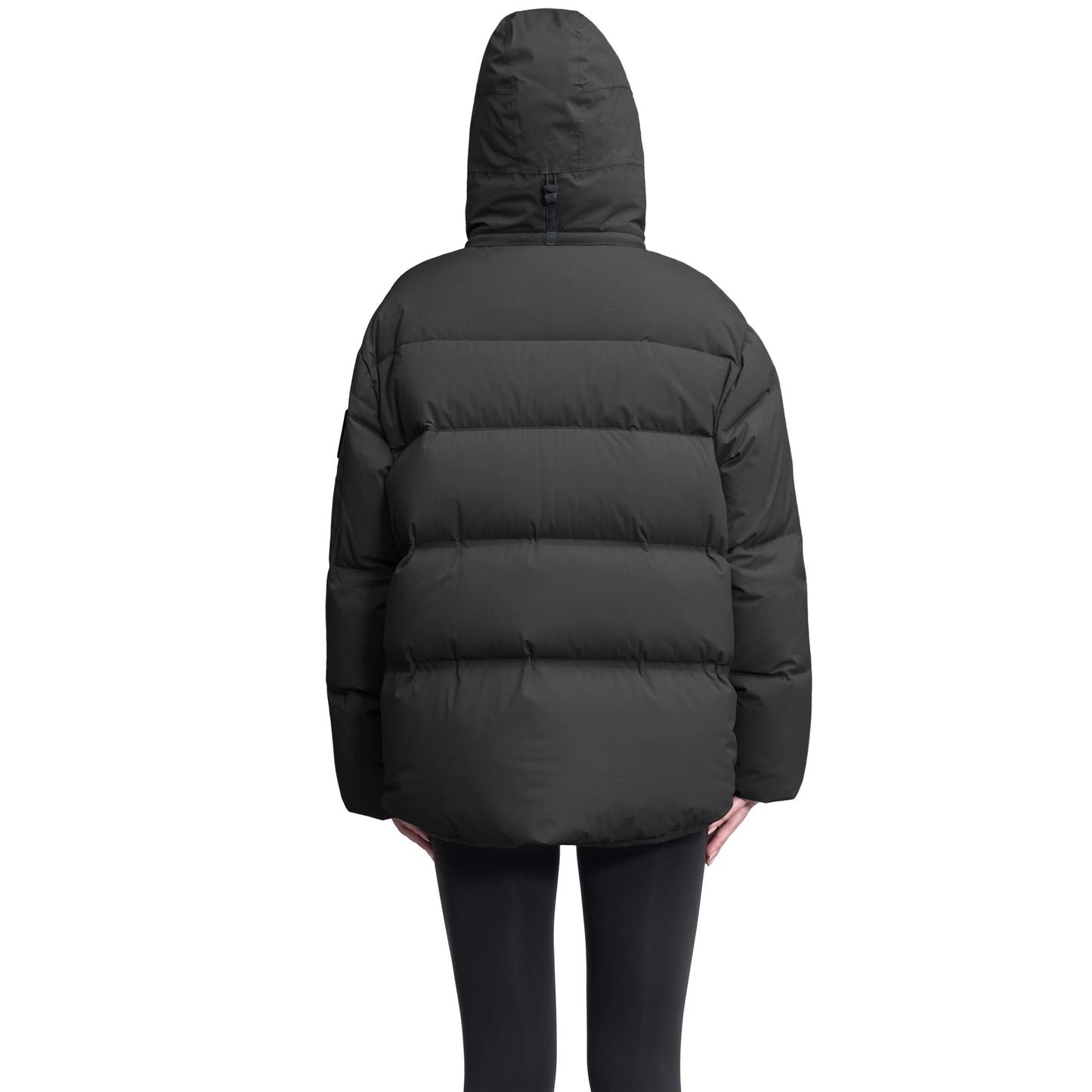 A backward-facing view of a person wearing the Nobis Una Women's Performance Puffer, featuring a black waterproof design and down-filled hood against a white background.