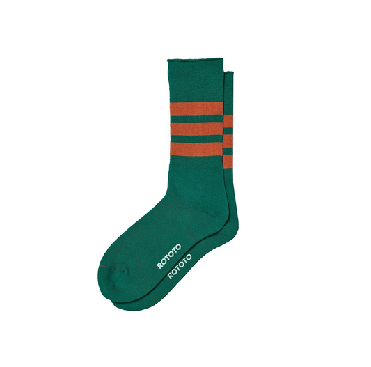 A pair of Fine Pile Striped Crew Socks in Green/Dark Orange by RoToTo features three brown stripes near the top and "ROTOTO" printed twice on the sole in white.