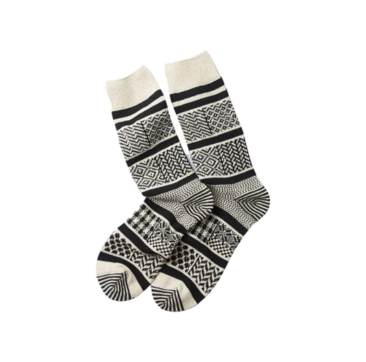 Displayed on a white background, RoToTo's Multi Jacquard Crew Socks in Ivory/Black showcase intricate geometric patterns. Made from a blend of silky texture and sturdy cotton, these socks exemplify the unique craftsmanship of Rototo.