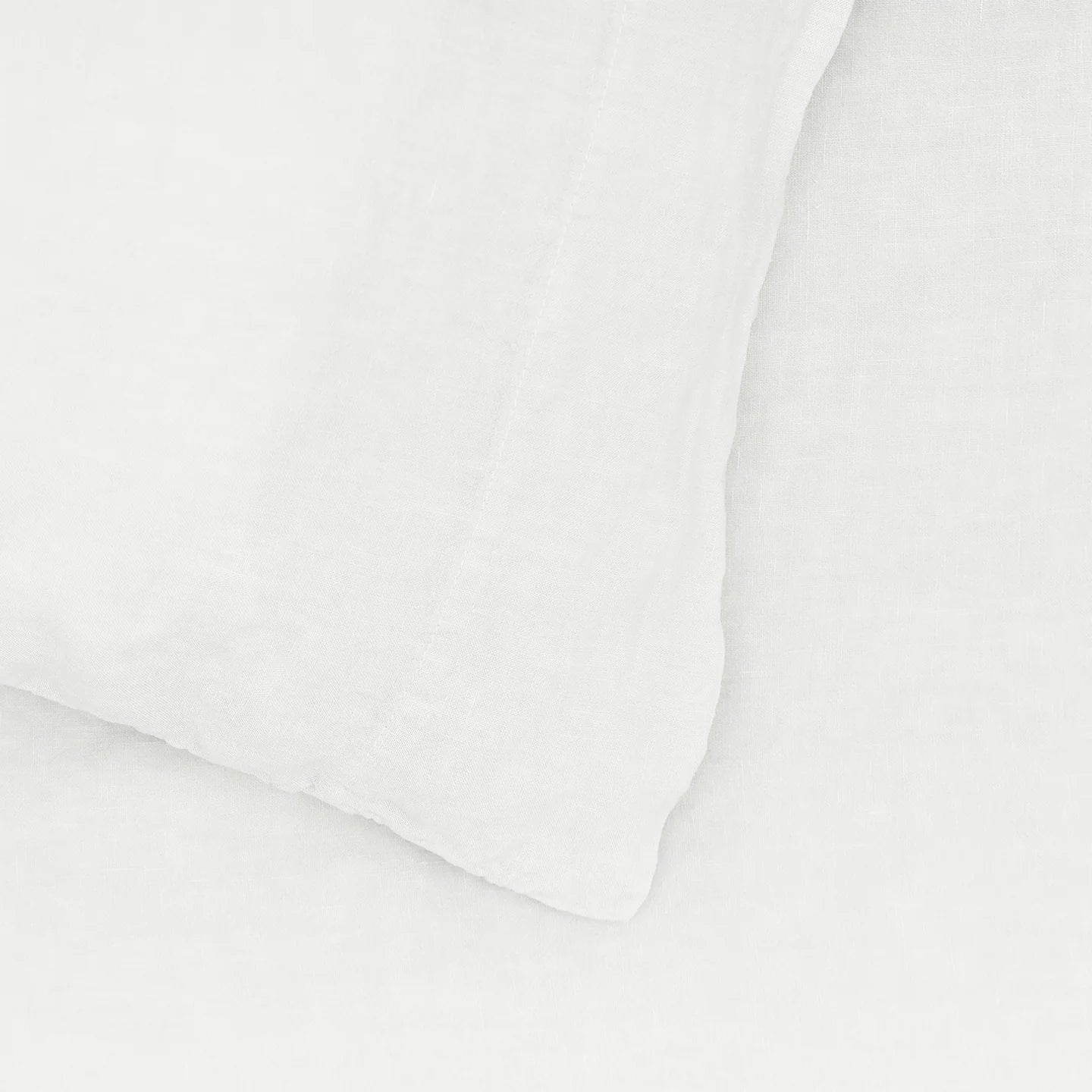 The Hawkins New York Standard Linen Pillow Case in white, part of a simple linen bedding ensemble, embodies understated elegance. Its European linen soft textures create a serene sleep environment.