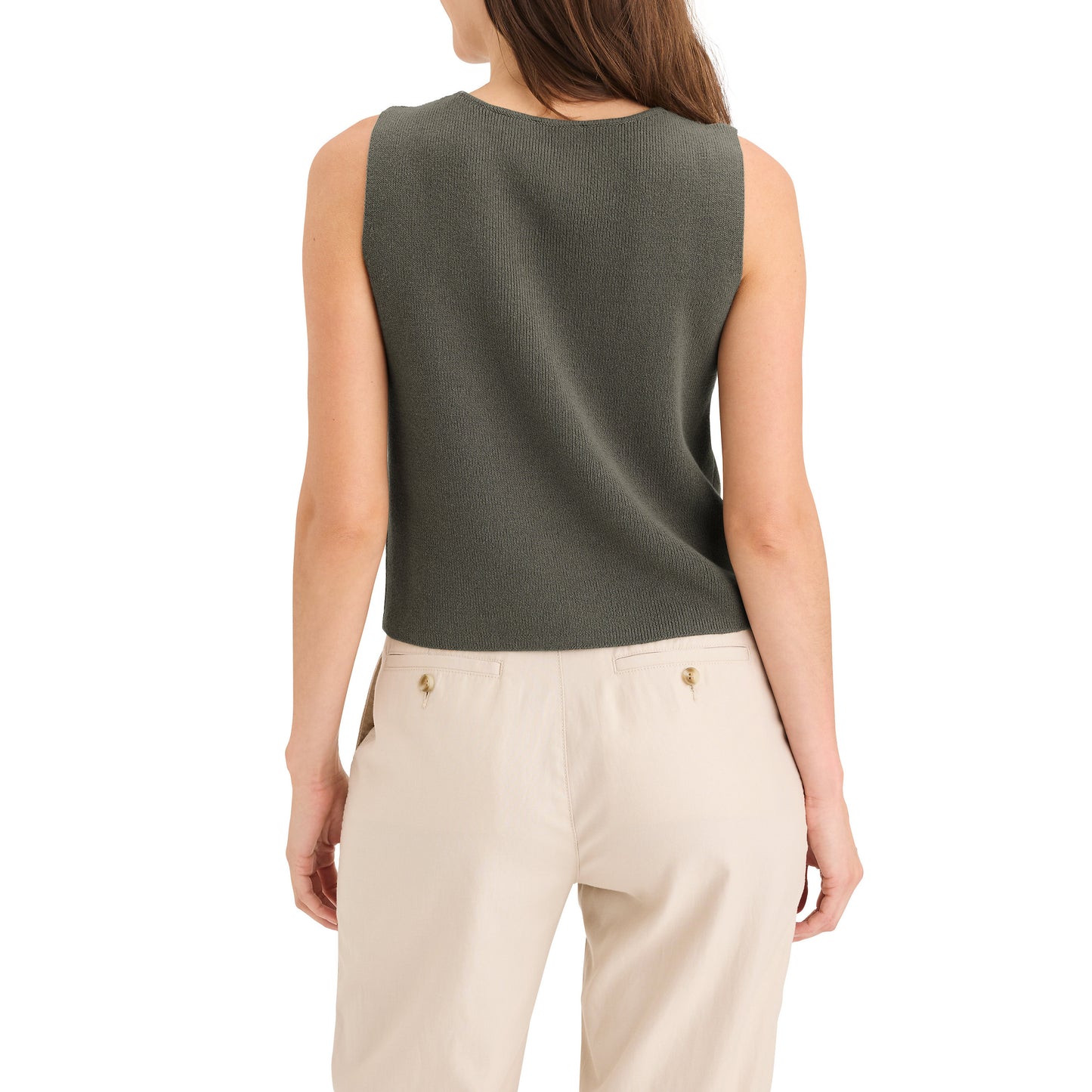 A person is seen from the back in a Dockers Women's Sweater Tank in dark green, featuring a sleeveless design, paired with light beige pants against a plain white background.