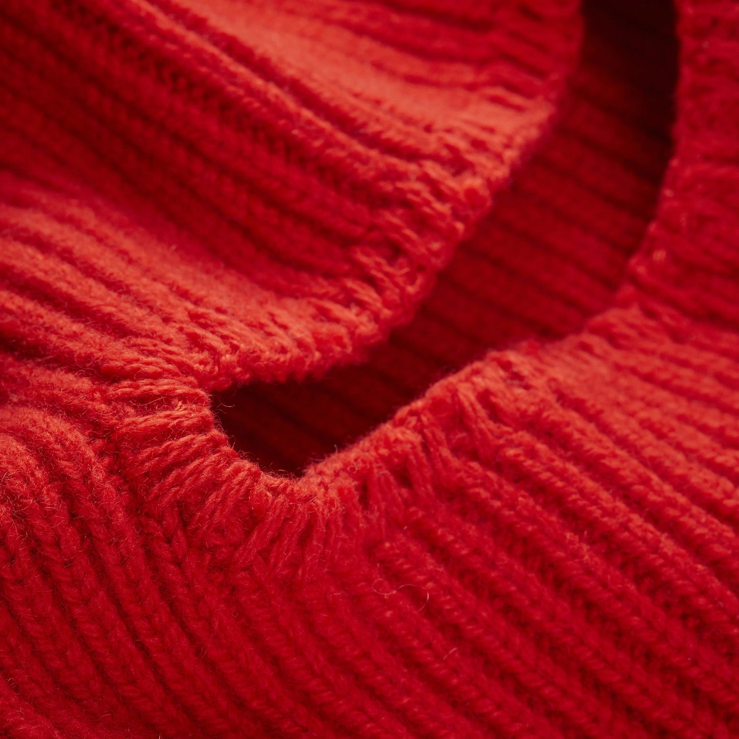 Close-up of a red Le Bonnet balaclava highlighting its ribbed texture and detailed stitching, crafted from limited edition cashmere.